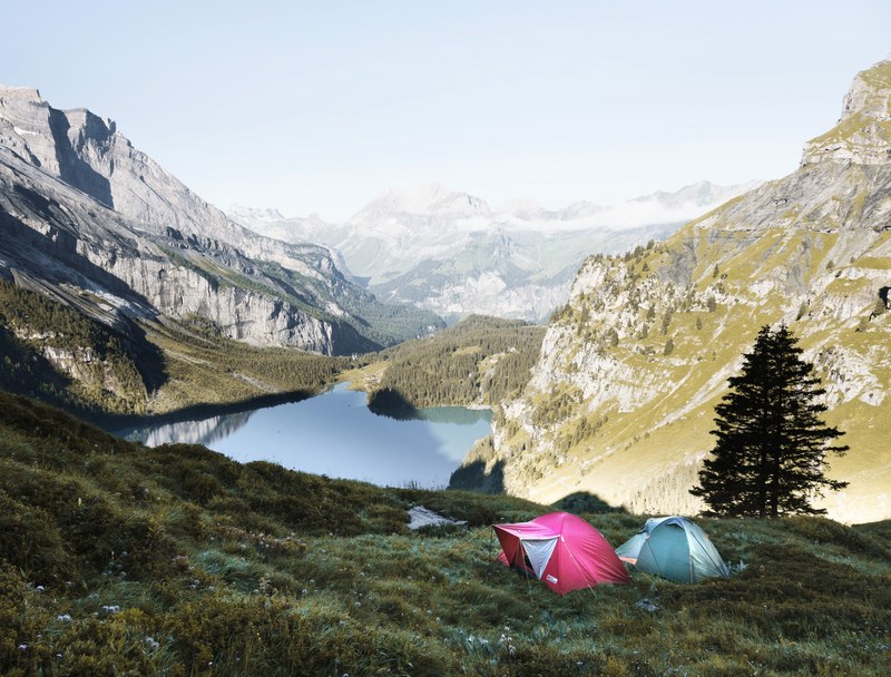 two tents on a mountainside near a small lake, tents by oeschinen lake 4k