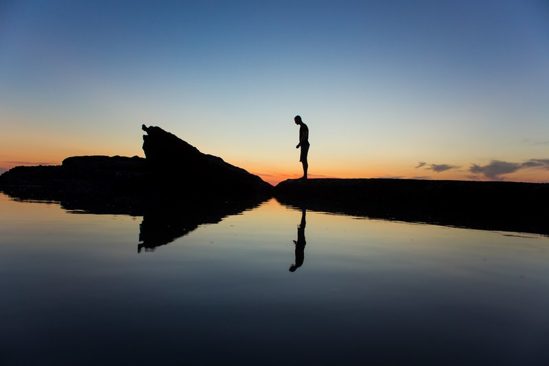 man silhouette standing on the rock with reflection at virginia beach after sunset, man silhouette standing 4k