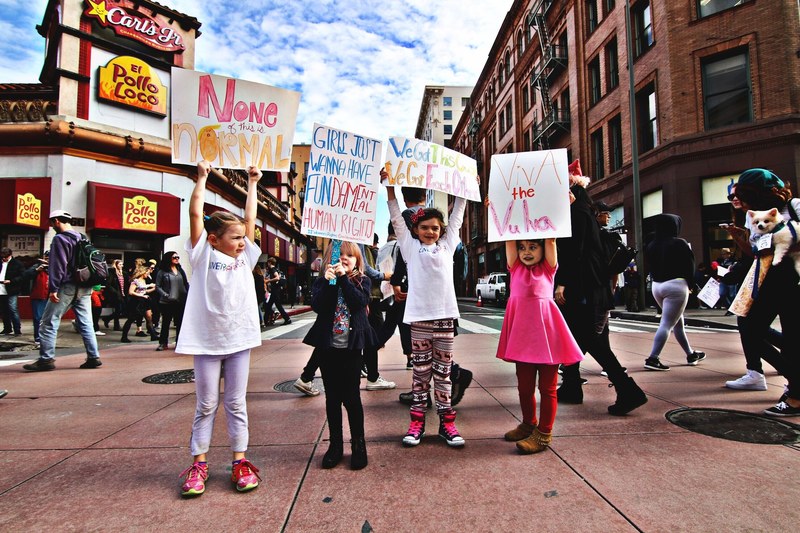 young girls protest at the womens march holding feminist signs and posters, the future is female 4k