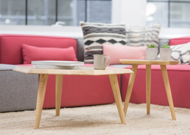 coffee tables with potted plants two books and a mug near a grey and pink sofa, coffee tables in front of a comfy sofa 4k