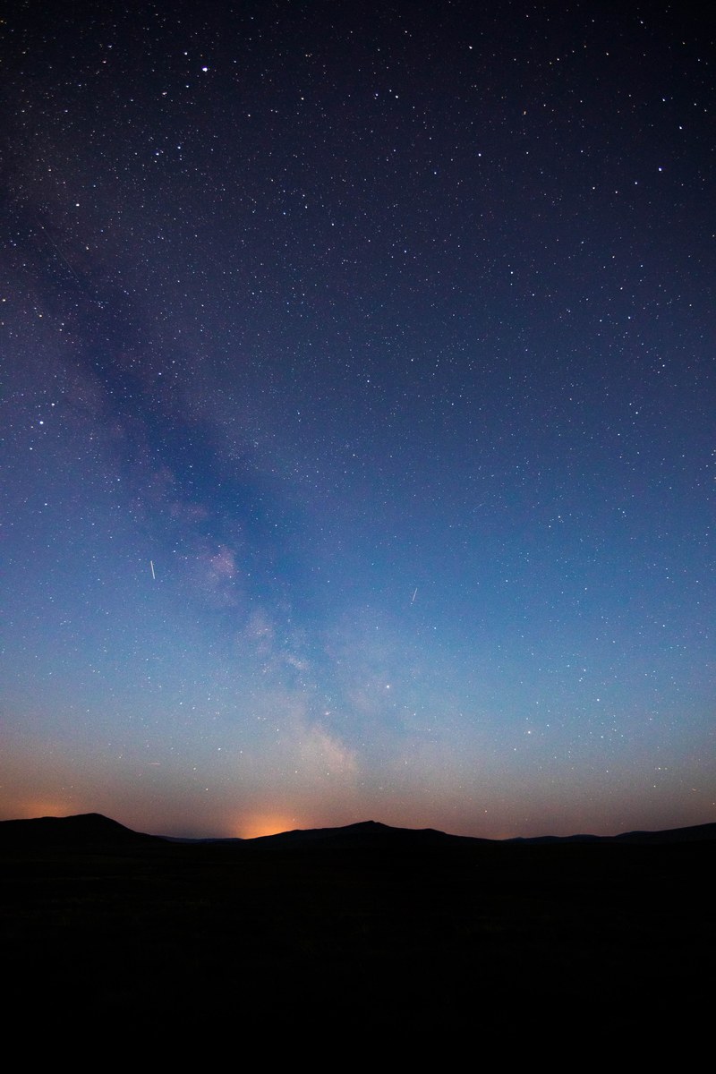 bright stars in the beautiful dark blue night sky over a silhouette of a mountain range, beautiful night sky 4k
