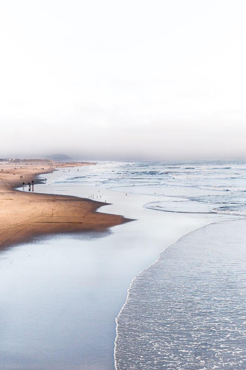 ocean washing on the sand beach on a cloudy day, sutro baths 4k
