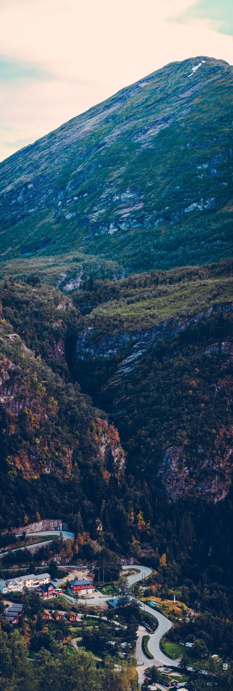 an impressive landscape of a lofty peak overlooking a tourist resort in geiranger, resort at the foot of a mountain 4k