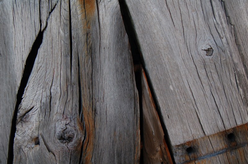 a close up of weathered wooden planks with visible knots, old shed wall in close up 4k