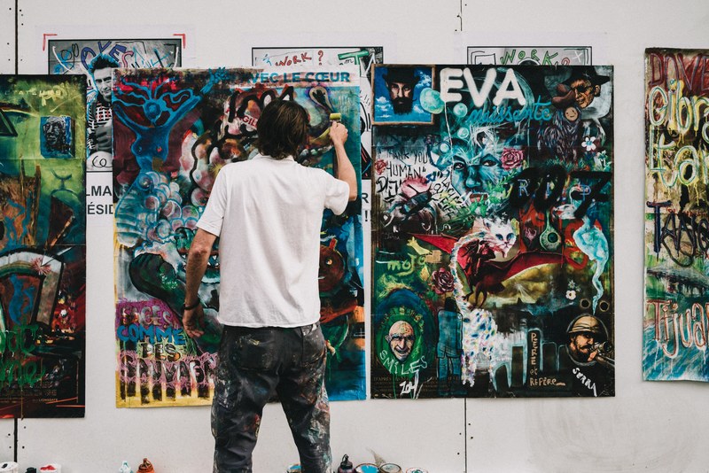 a man working on a colorful graffiti painting, person working on painting 4k