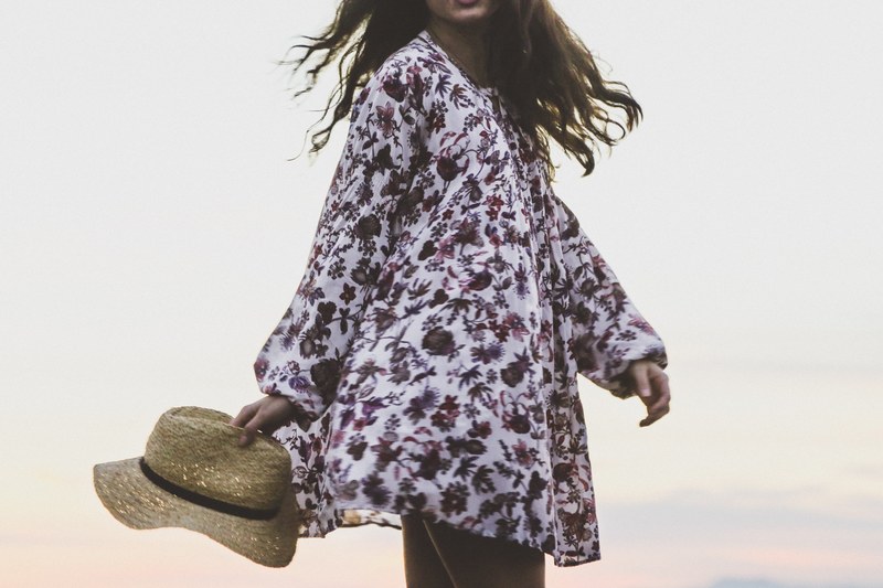 woman in floral shirt holding a hat at newport beach, be yourself 4k