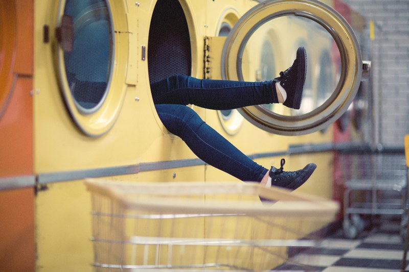 a persons legs sticking out of a large washing machine, inside a washing machine 4k
