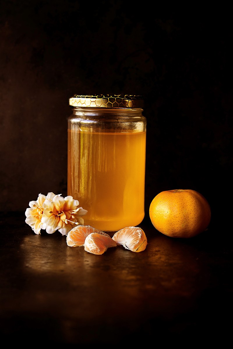 homemade jar of honey orange clementine slices and a flower blossom, honey and clementines 4k
