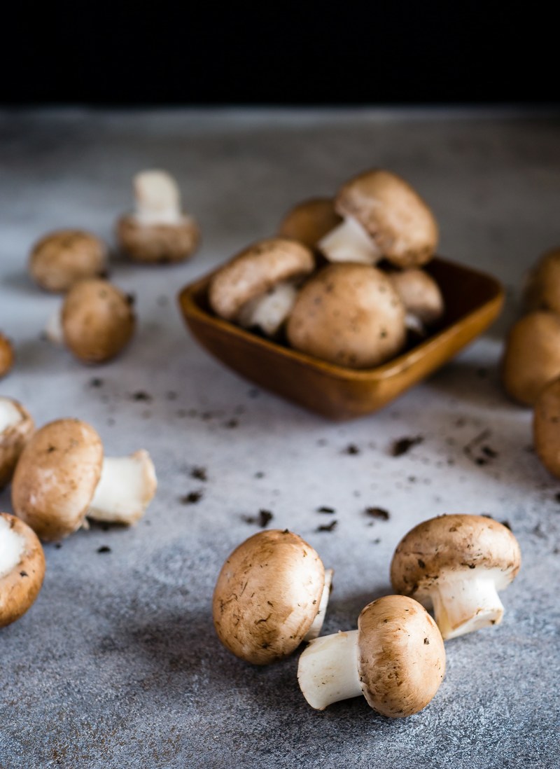 mushroom caps on a table and in a bowl, _unwashed mushrooms 4k