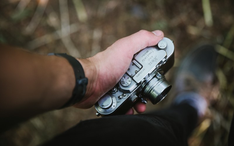 a man gripping his camera in his hand, _tight hold camera 4k