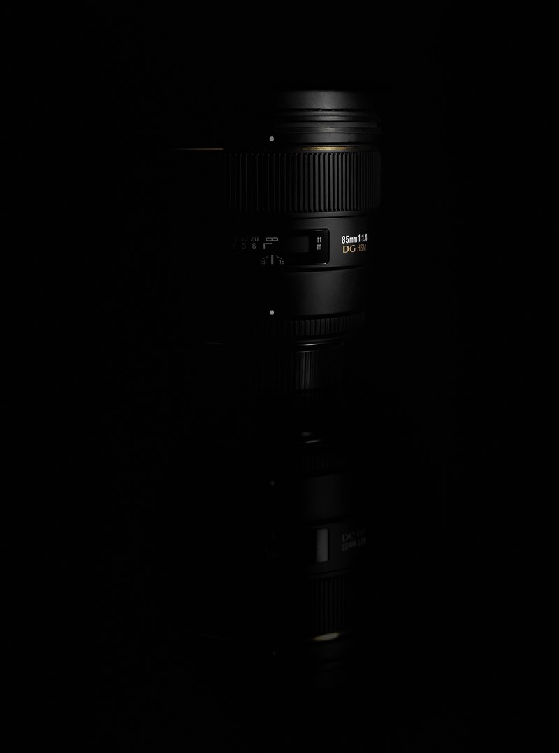 black 85mm dslr camera lens on a black reflective surface, 85mm dslr lens 4k