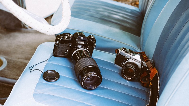 photographers nikon and olympus cameras on a car seat, classics in a classic car 4k