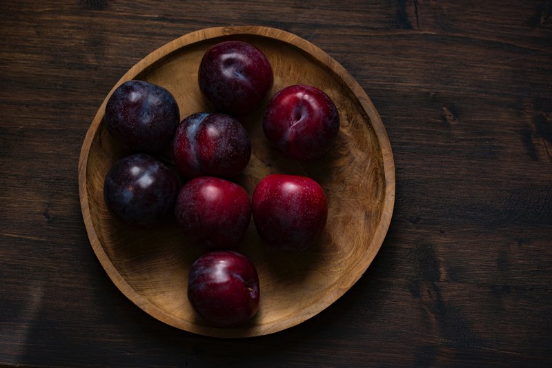 wooden bowl of fresh plums in the kitchen ready to eat, plums 4k