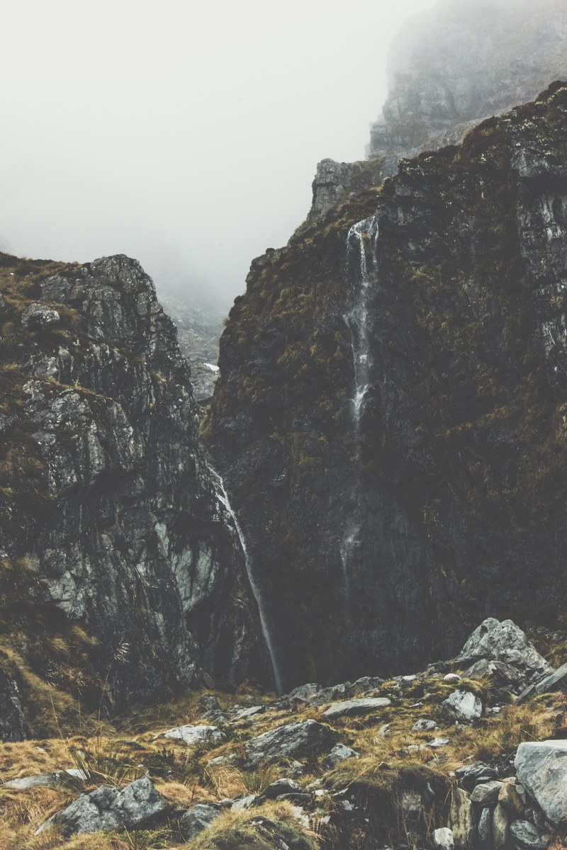 waterfall on a scenic mountainside on a misty morning in mount aspiring national park, waterfall in a national park 4k