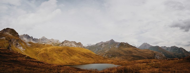 swiss alps and grassy hillside on a cloudy day, mountains with a view 4k