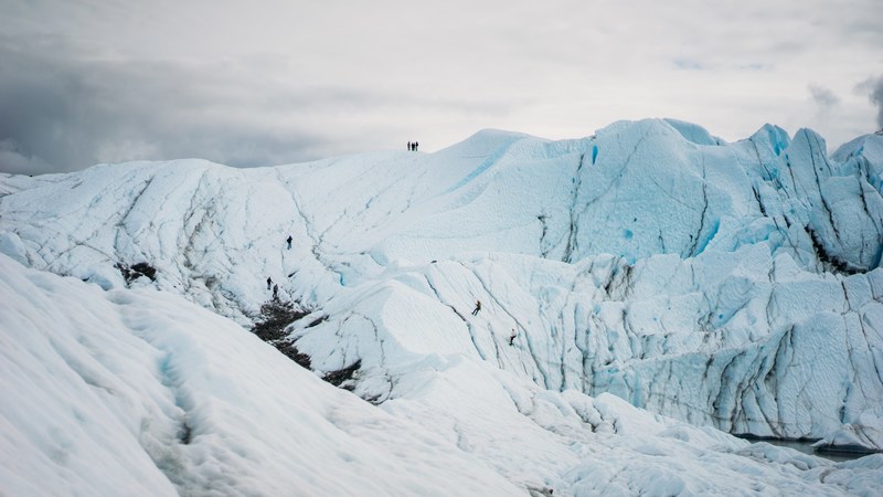 a landscape view of snow covered mountains with a hiker on top of it, _snow covered mountains with hiker 4k
