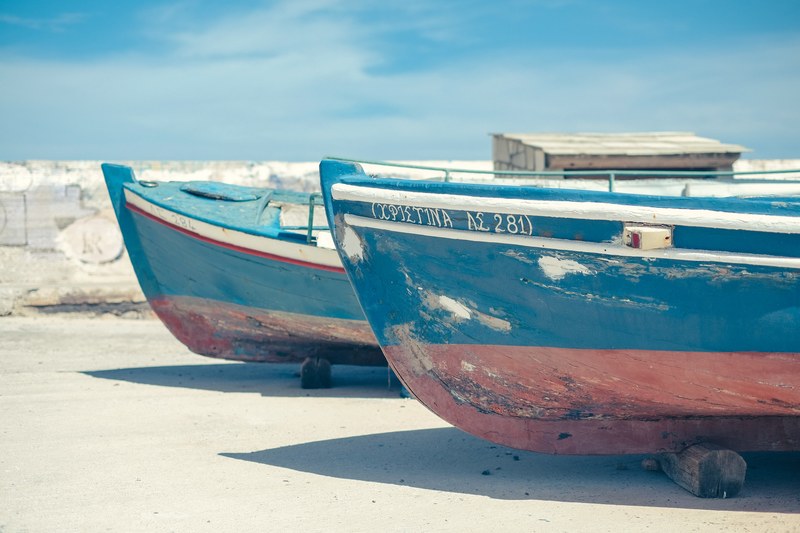 two blue and red boats on the sandy shore in skopelos, two boats on the sand shore 4k