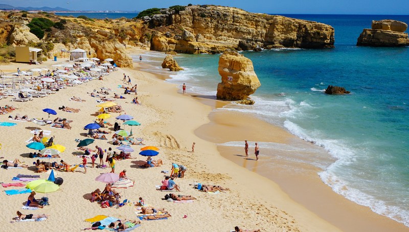 a high shot of people resting and sunbathing on a sandy beach, vacationers on a sunny beach 4k