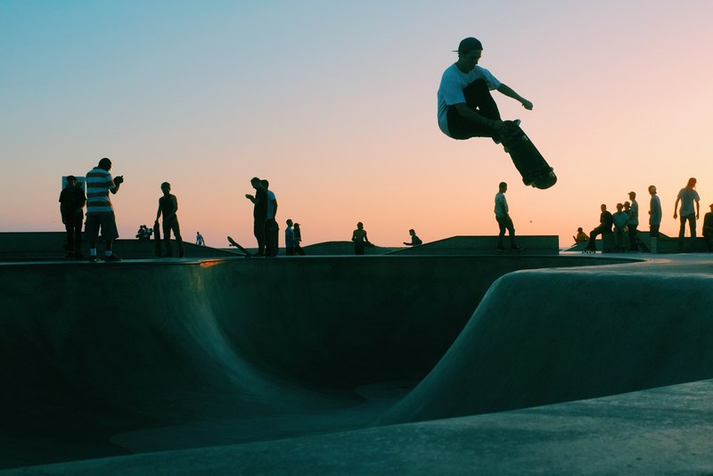 skateboarder performing an aerial during sunset at venice skatepark in los angeles california, skateboarding at venice skatepark 4k