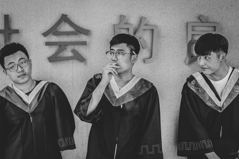 three young men in graduation robes are standing next to a wall, _2 4k