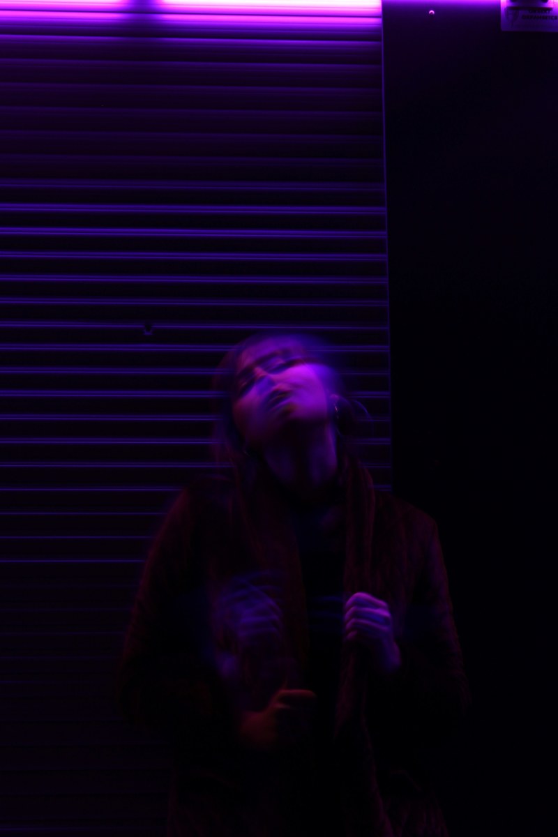 a motion blur shot of a young woman under purple lighting in kaliningrad, _motion blur woman kaliningrad 4k