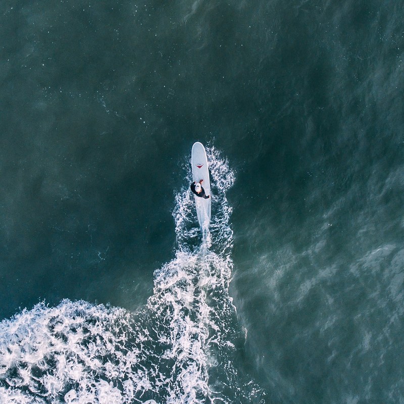 drone view of a surfer on a surfboard in ocean at beaches jacksonville beach florida united states, aerial surfer shot 4k