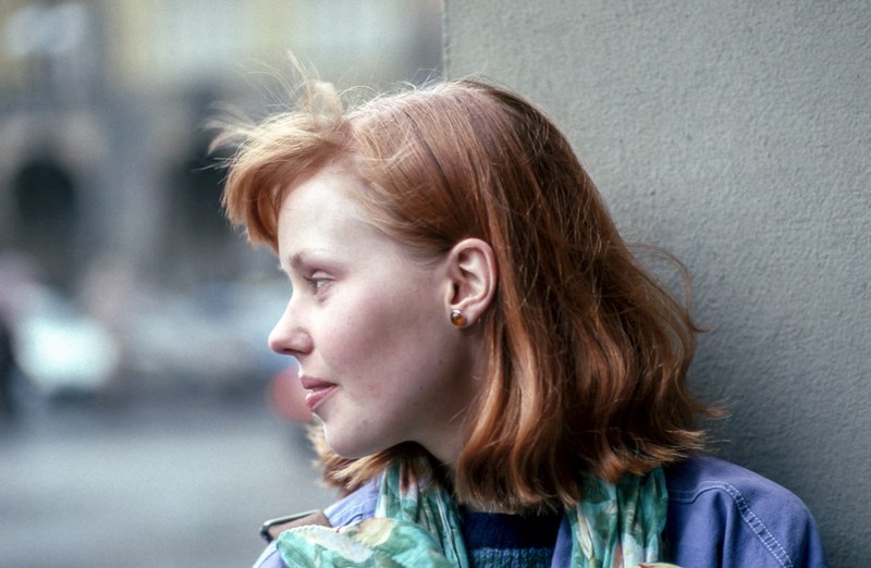 woman with a 90s hairstyle and outfit leaning against a wall, 90s chic 4k