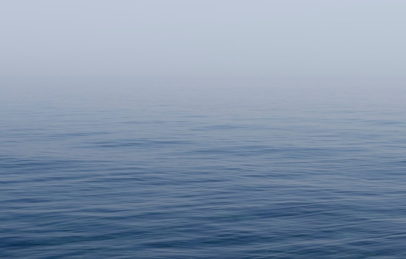 calm blue sea covered in a soft mist, soft sea mist 4k