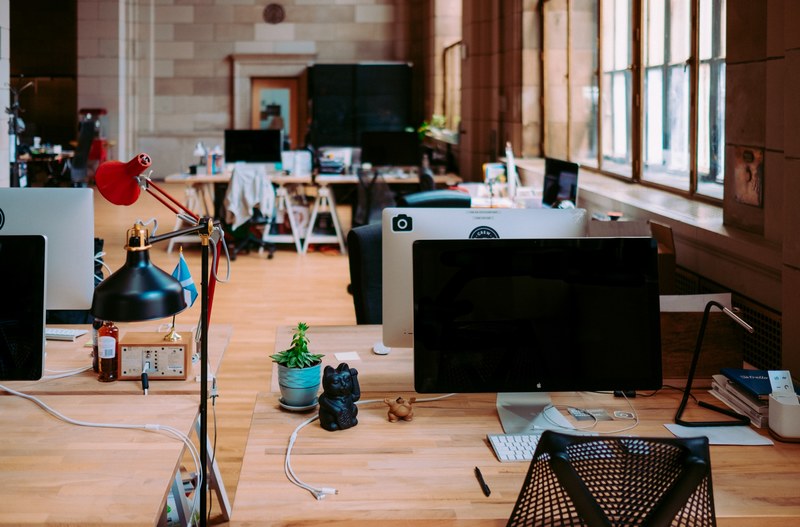 busy desks with imac computers in an empty workspace, unsplash hq crew collective amp cafe montreal 4k