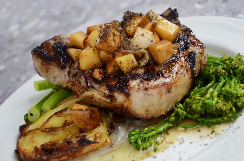 grilled pork chop with sauteed potatoes and a side of broccoli on a white plate, pork chop dinner 4k