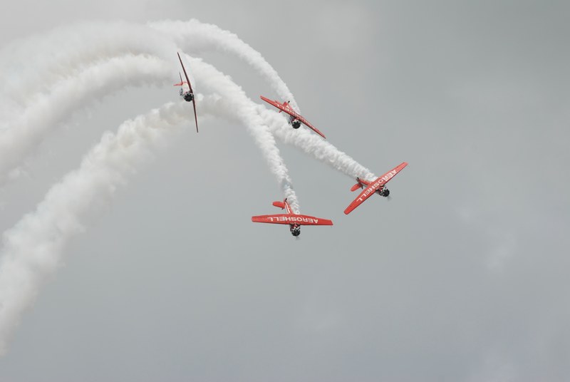 white smoke trails behind four small airplanes flying close to each other, aeroshell team at sun n fun 2008 4k