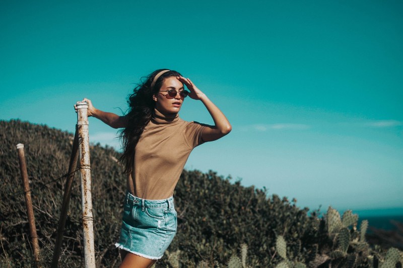 a woman shades her eyes as she looks into the distance in the hills of malibu, searching 4k