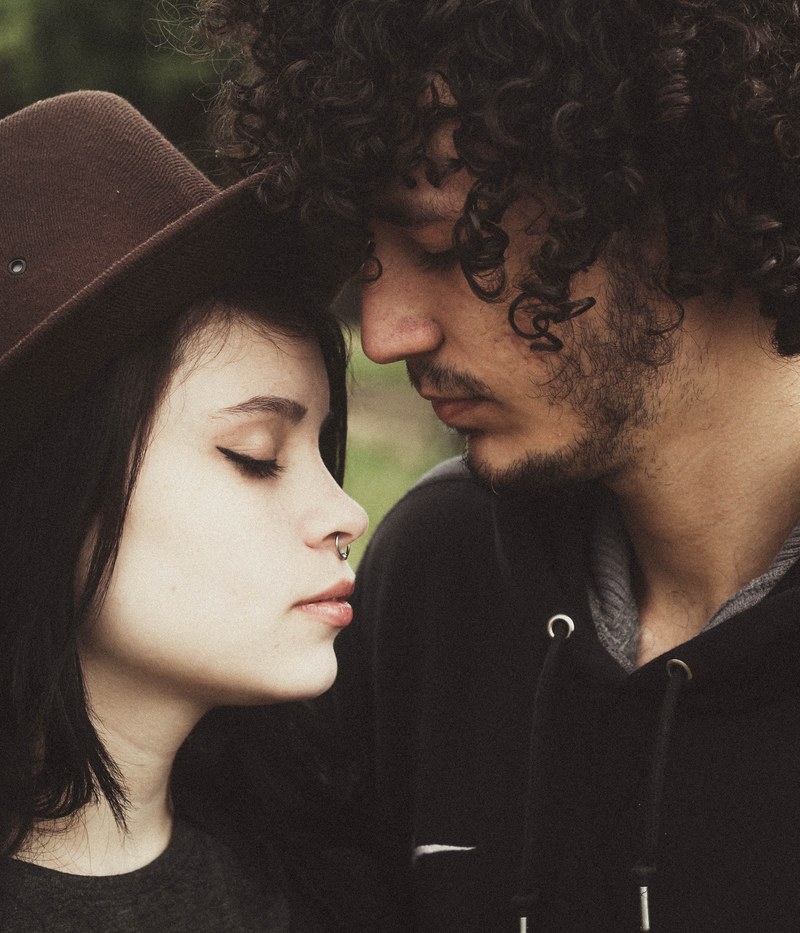 a hip man and a woman with their faces leaning together and eyes closed, faces leaning together 4k