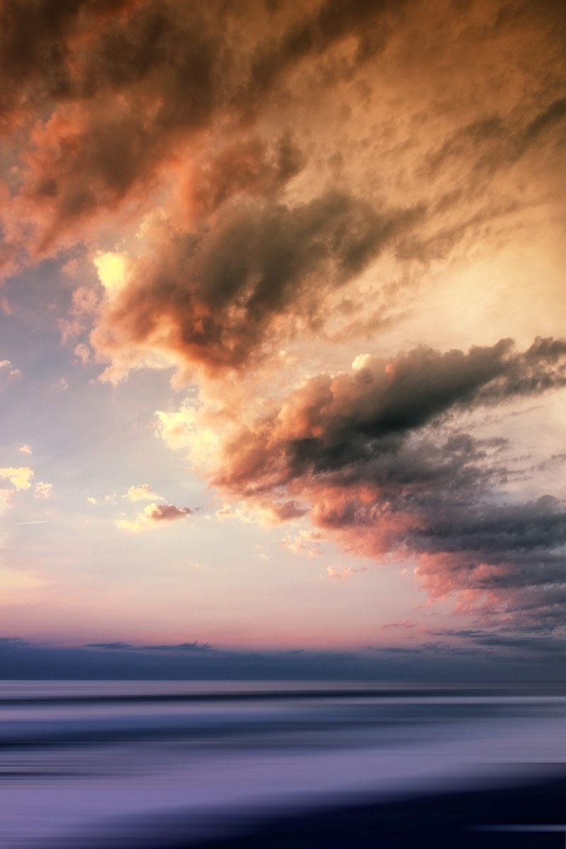 a beautifully colored sky and clouds over the water during sunset or sunrise, colored sky 4k
