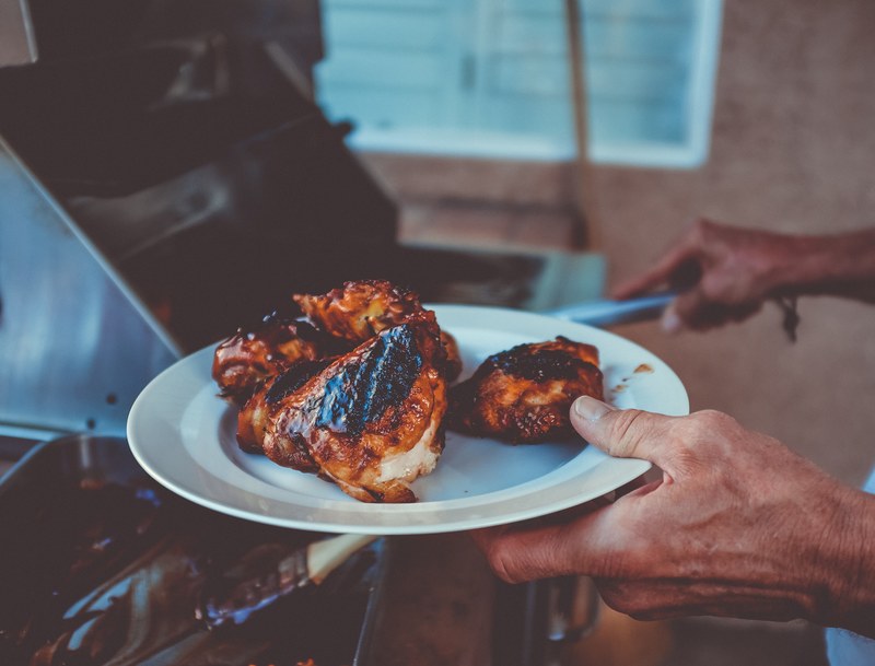 hand holding a plate of bbq chicken breasts coming off a grill in green valley south, dinner is served 4k