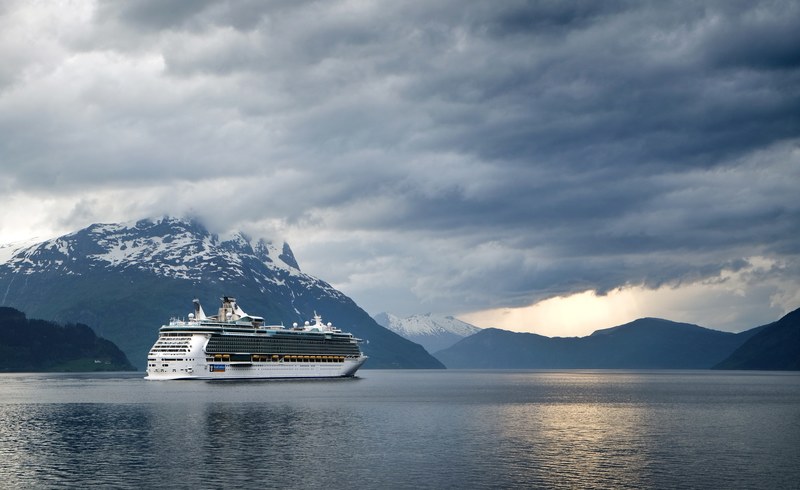 a cruise ship on a mountain lake with heavy clouds above, independence of the seas 4k