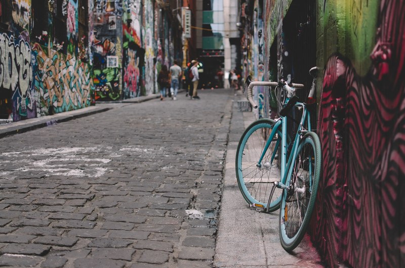 a blue bicycle propped against a wall in a graffiti lined alleyway in hosier lane, hosier lane graffiti 4k