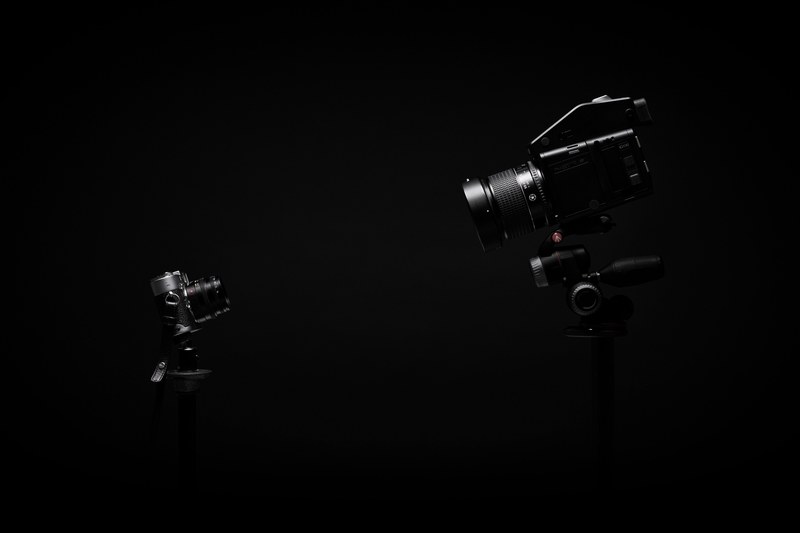 a dim shot of a video camera and a photo camera on tripods, photo camera and video camera 4k