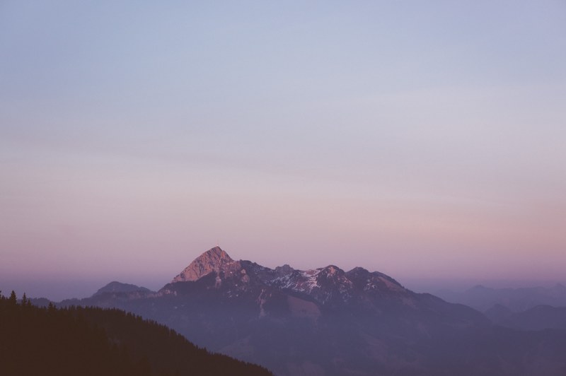 a mountain massif with a radio mast on one of its peaks during sunset, distant mountain massif at dusk 4k