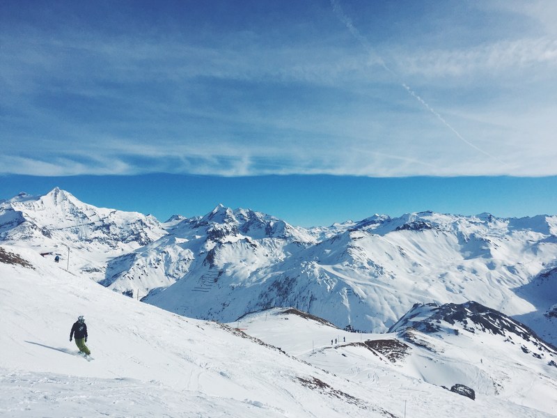 snowboarder on top of snowcapped mountains high up in the sky, snowboarder in the clouds 4k