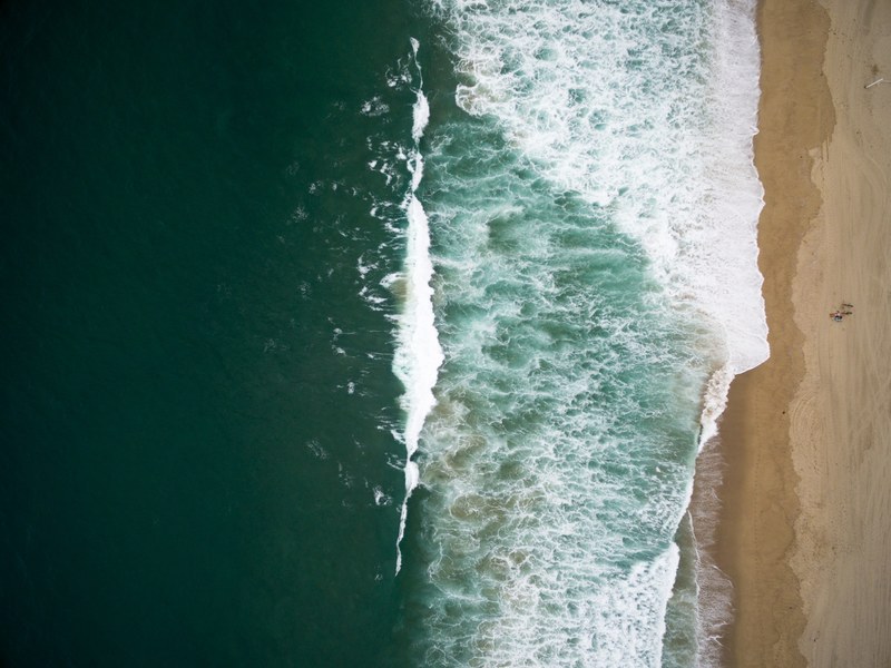 drone aerial view of the ocean washing on the sand beach in south redondo redondo beach california, drone view of ocean waves 4k