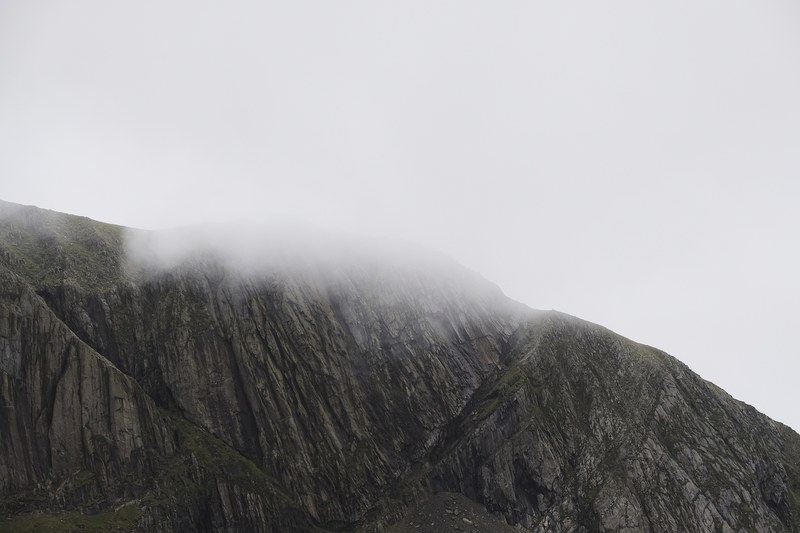gray rocky mountain cliff covered in clouds and fog, snowdon in the clouds 4k