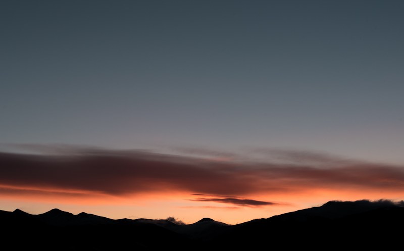 silhouette mountain range at silverthorne with an orange dawn or dusk sky covered by dark cloud and clear gray sky, dawn or dusk horizon and mountain range view 4k