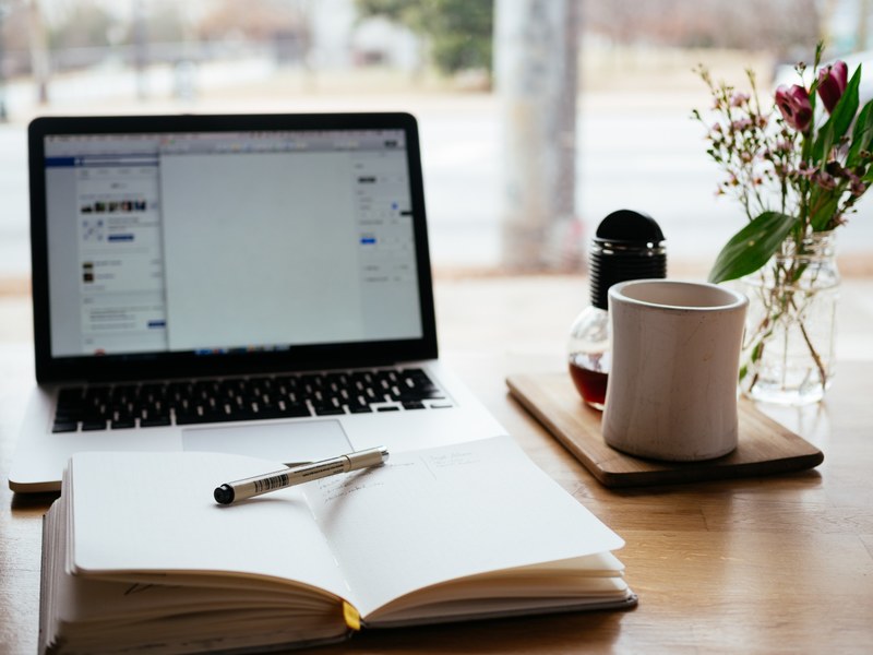 an open notebook on a wooden surface in front of a laptop, laptop and notepad 4k