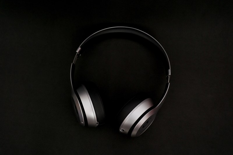 silver and black earphones in black background standing upright, beats solo2 wireless 4k