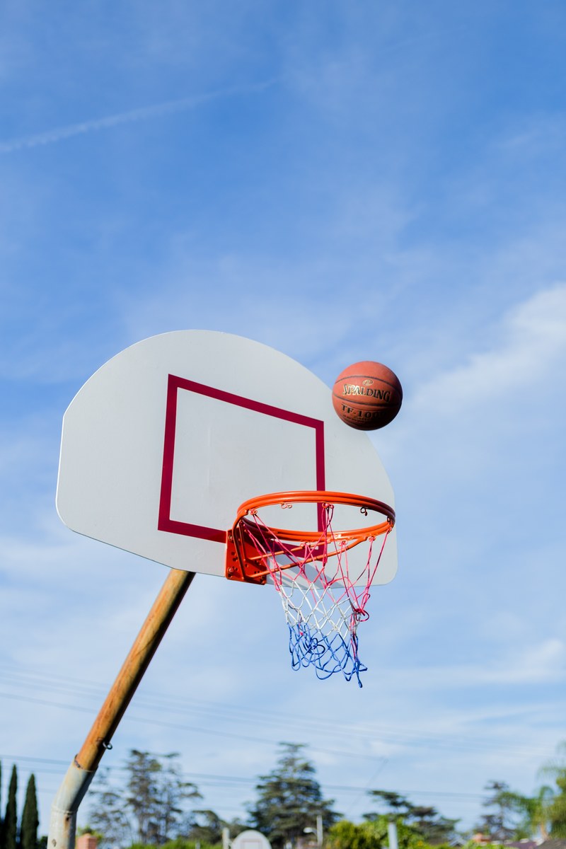 a basketball about to enter a bball net in an outdoor court, _hoops 4k