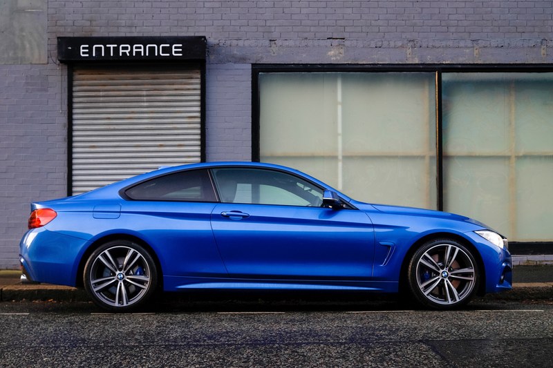 shiny blue sports car parked on a city street, blue car entrance 4k