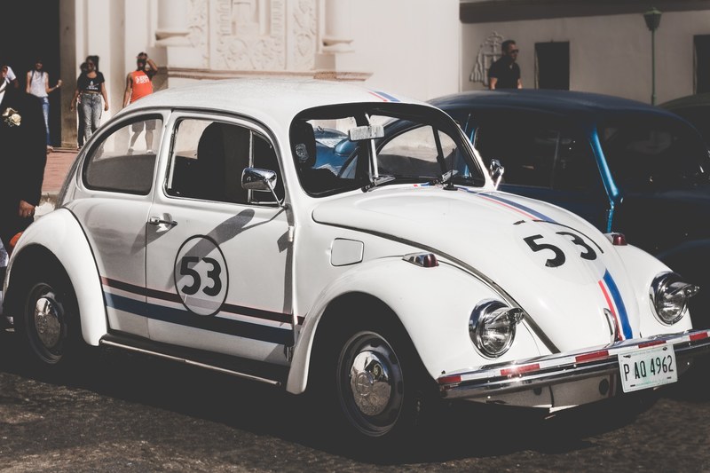 white volkswagen herbie beetle numbered 53 with stripes showcased on the street of comayagua, white volkswagen herbie beetle on the street 4k