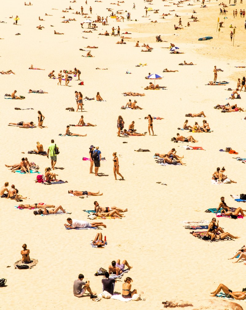 tourists sunbathing on a large sandy beach, sunbathing on bondi beach 4k