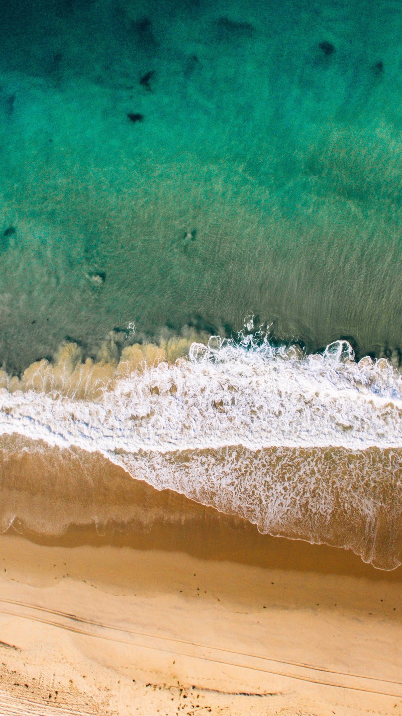 drone view of the waves crashing on the sand beach shore, drone view of ocean waves 4k